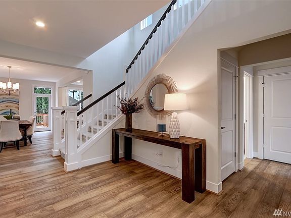 Inviting entry with warm hardwood flooring and elegant white painted open railing.