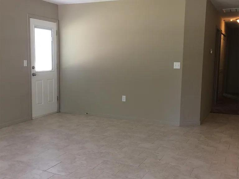 Large living room with ceiling fan and patio door