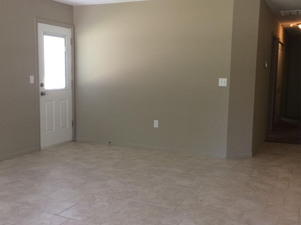 Large open living room with ceiling fan & side patio door