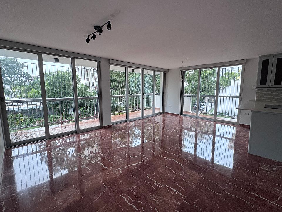 Living area with ample L-shaped balcony overlooking residential Luchetti Street.