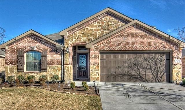 Welcome to 115 Hendelson Lane!  Attractive exterior featuring a brick/stone combination, lovely painted garage door, and a beautiful front door with iron detail.