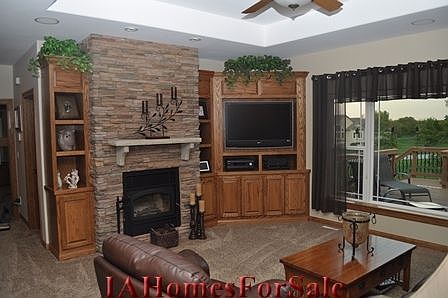 Living Room With Custom Built In's, Wood Stove, and Tray Ceiling