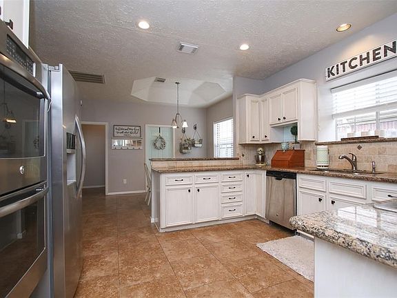 True chef's delight in this kitchen that boasts double ovens, gas cooktop, granite counters, travertine backsplash, recessed lighting, and refinished cabinets.  Nothing to do in here except bring your recipe books and start cooking!