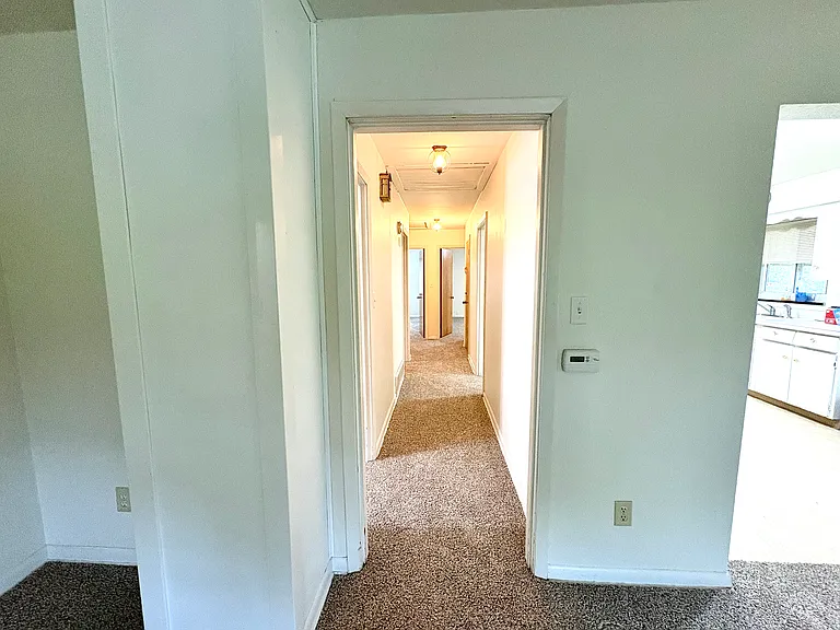 Hallway to bedrooms, bathroom, and utility room