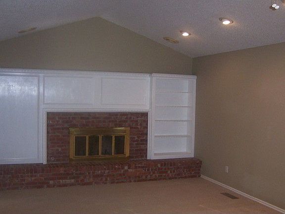 Large living area with wet bar, fireplace, and french doors.