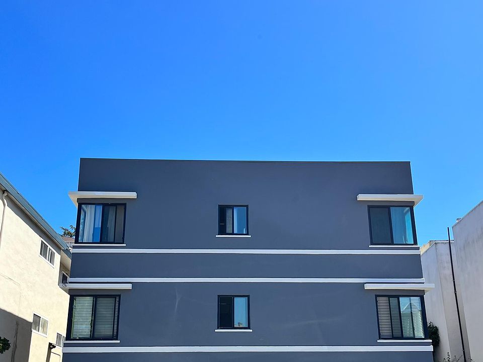 Apartment building with enclosed parking and extra parking in the front of the apartment.