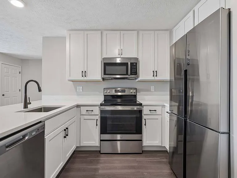 Crisp white cabinetry and stainless steel accents bring a fresh, contemporary feel to a kitchen designed for both style and functionality.