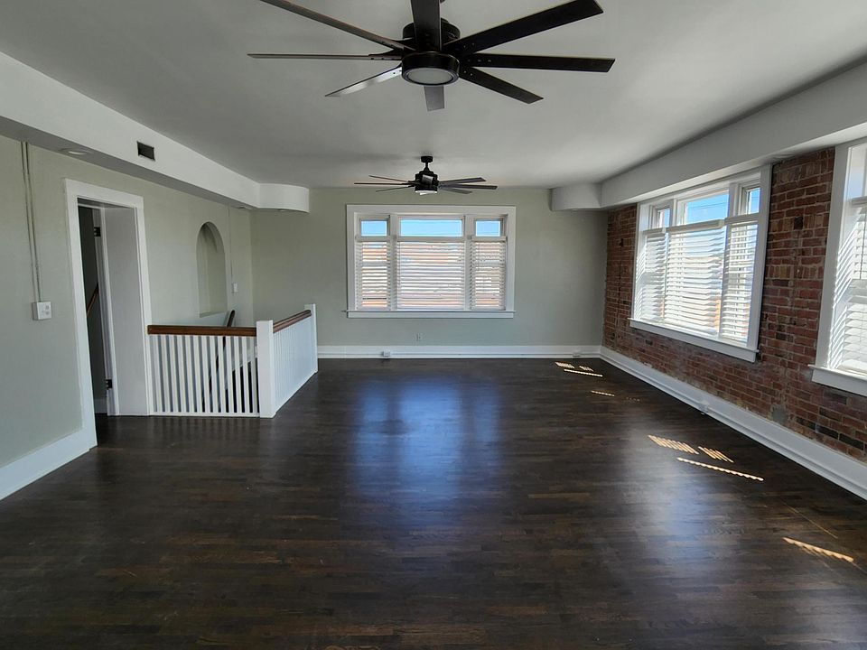 The dark hardwood floors provide a rich and sophisticated touch, while the large windows allow for an abundance of natural light to flood the space.