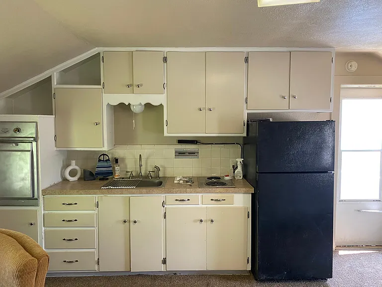 Full kitchen with stove top, oven and refrigerator.