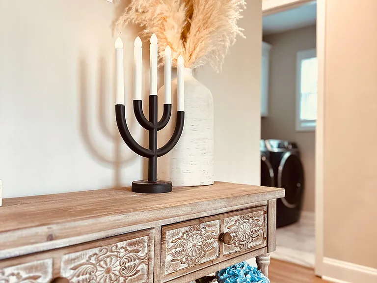 Entry hallway with decorative console table offers a convenient drop zone near the laundry area and main living spaces.