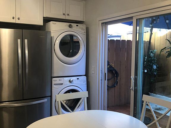 Washer/drier stacked, kitchen area and sliding door to patio.