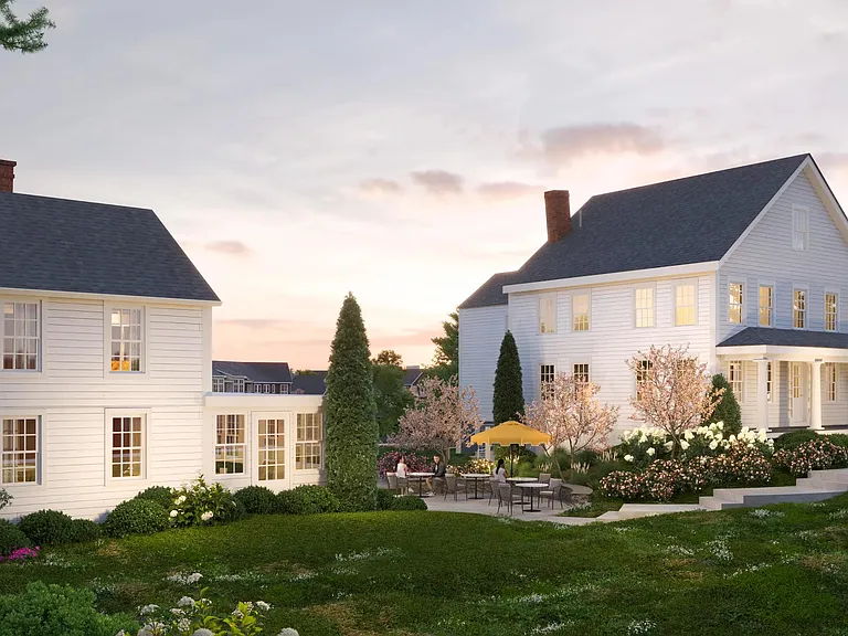 Community clubhouse with outdoor patio seating, landscaped grounds, and New England_inspired architecture.