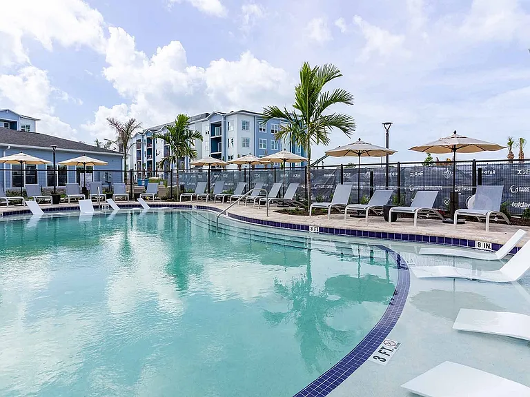 Cool off in the resort-style pool, framed by sun loungers, shaded umbrellas, and palm trees for the ultimate Fort Myers staycation.