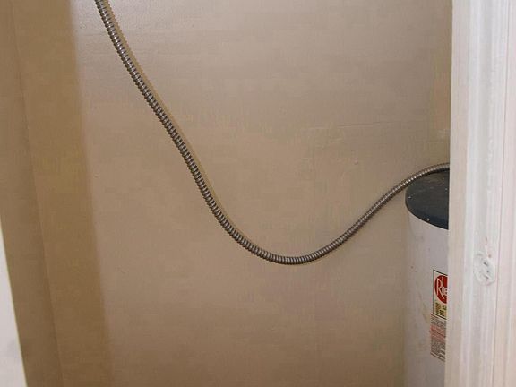 Closet with water heater off of front room