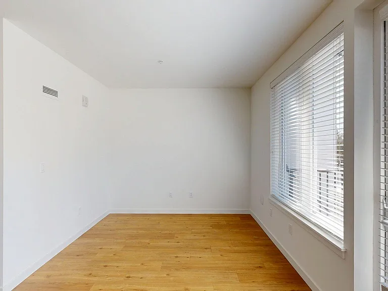 Spacious apartment Bedroom with Wood-Style Flooring.