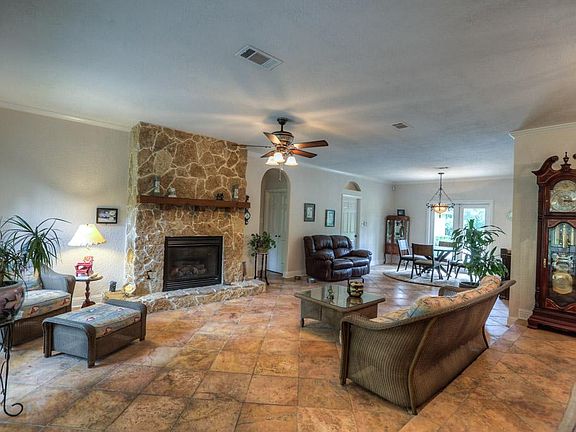 Large family room is accented by rock gas log fireplace.
