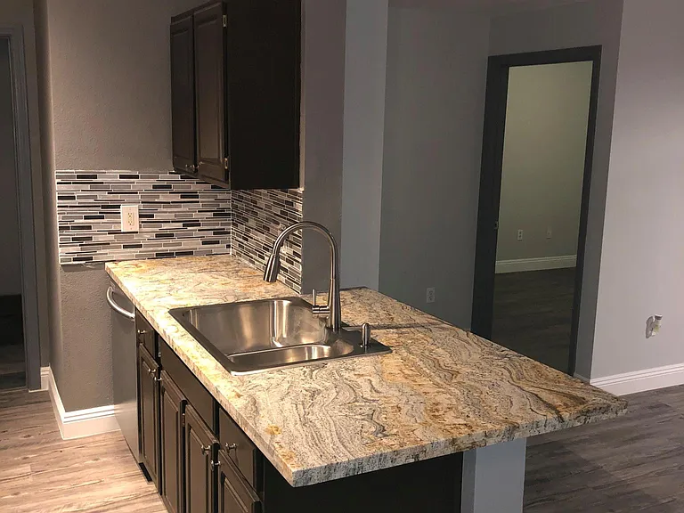 View of Kitchen with granite and backsplash.