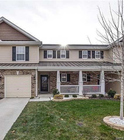 Cottage-Style townhouse with brick/vinyl exterior and a seating area on the front porch.