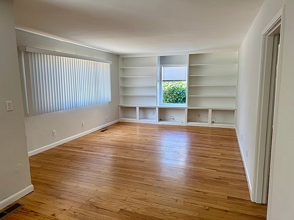 Living room with built in shelves, large window, plenty of light