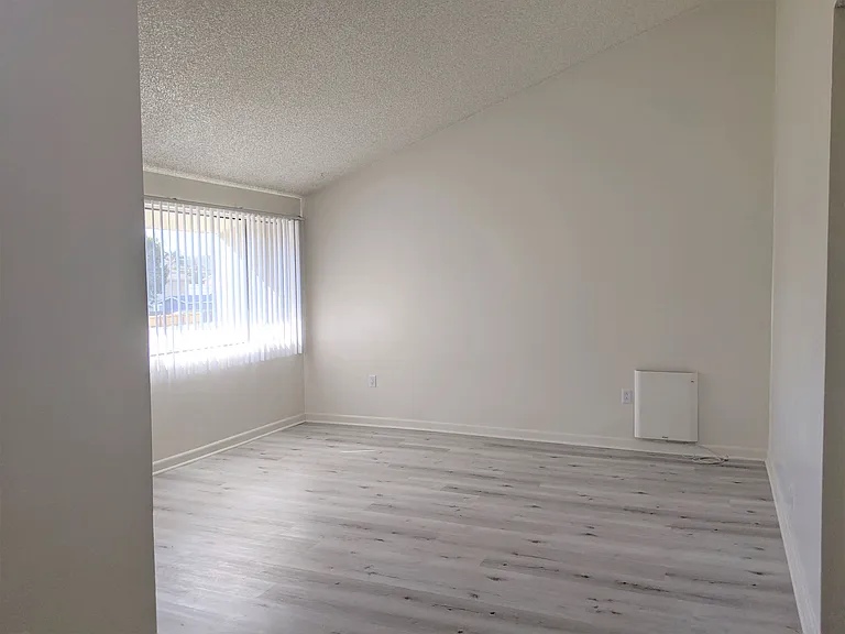 Large window with vertical blinds in spacious living room at the Steckel Apartments in Santa Paula, California.