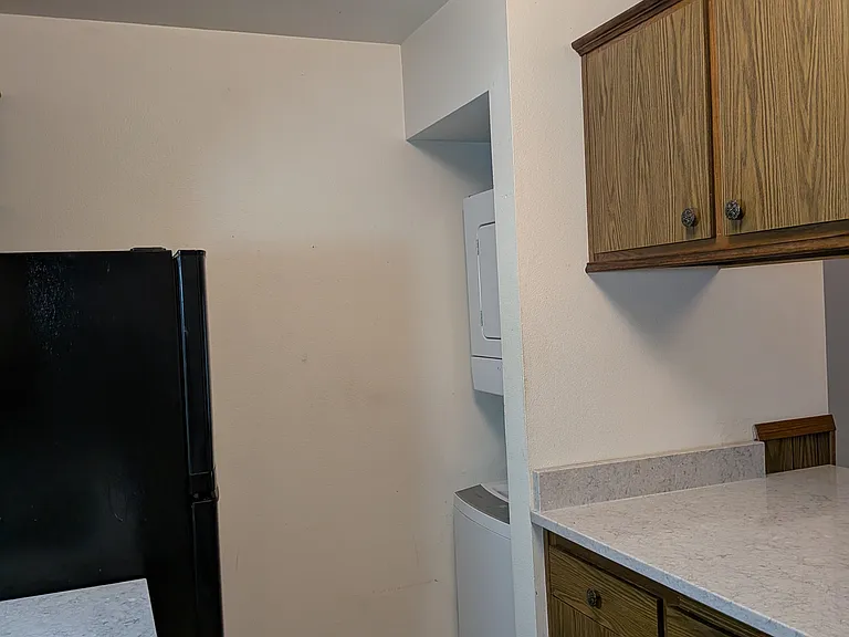 Another view of the kitchen showing washer-dryer combo at the corner