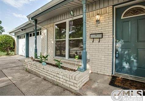 Covered front porch and flower bed  welcome you.