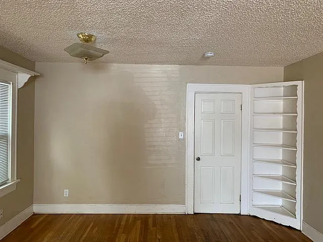 Dining area in living room. Notice the vintage corner cupboard. Door goes to the kitchen