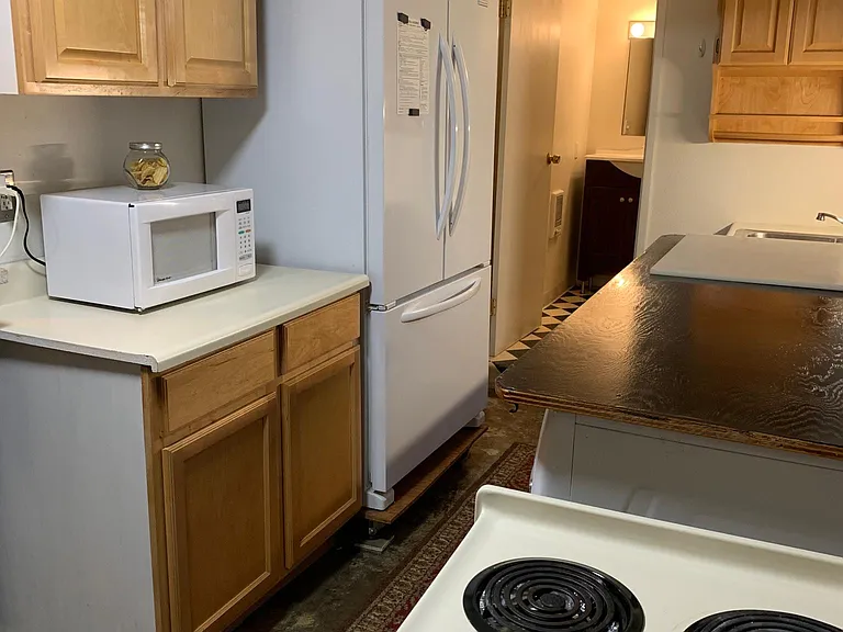 LARGE DUTCH DOOR REFRIGERATOR AND DOORWAY TO BATHROOM.