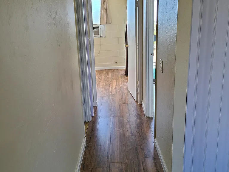 Condo hallway to 2 bedrooms and bathroom. Includes hallway closet with folding door closure.