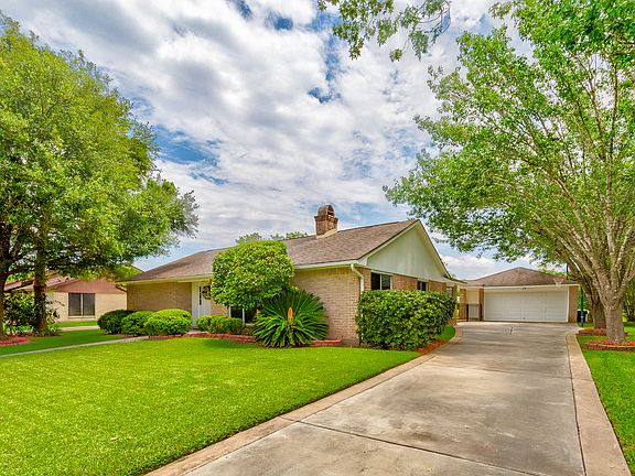 Welcome home, to shaded front yard with large oak tree.