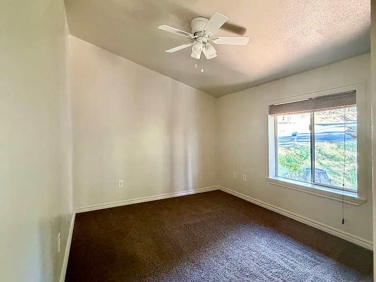 Bedroom #1 with mirrored closet, ceiling fan, and blackout shades