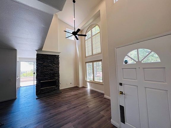 Open Floor Plan | New Floors + New Paint + New Ceiling Fan + Stacked Stone Fireplace + 2-story Windows & Ceilings