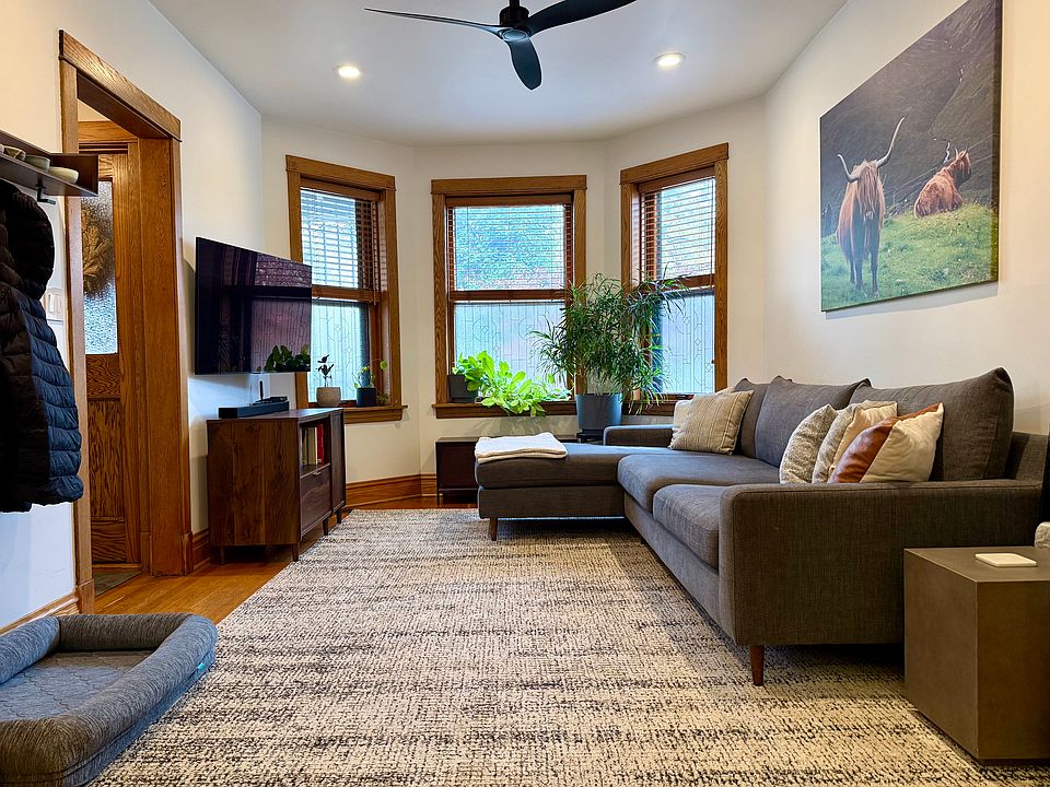 Living room with bay window lets in abundant daylight. Removable window decals for privacy.