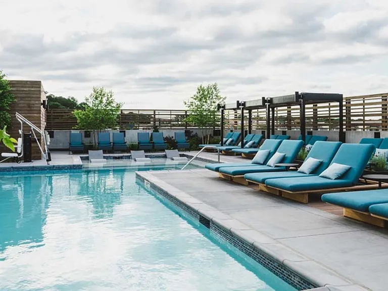 Resort-inspired pool with cabanas and lounge sun deck seating