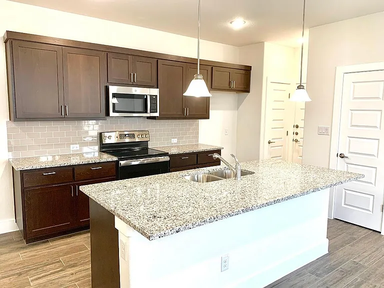 Kitchen has large granite island with bar style seating.