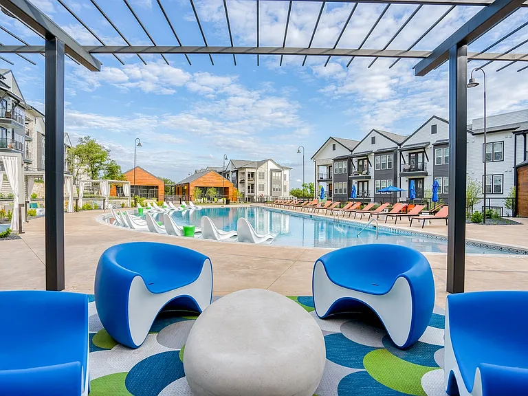 Oversized crescent shaped pool features cabanas and a sun deck.