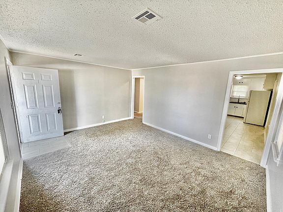 Living room showing tile entry and view into large kitchen
