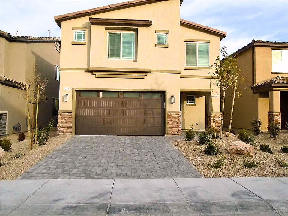 Welcome to 384 Borato CT! This stunning exterior blends modern desert architecture with sleek lines and a neutral palette. Notice the drought-tolerant landscaping, stone-accented pathway, and shaded entryway_perfect for Las Vegas living. The 2 Car Garrage