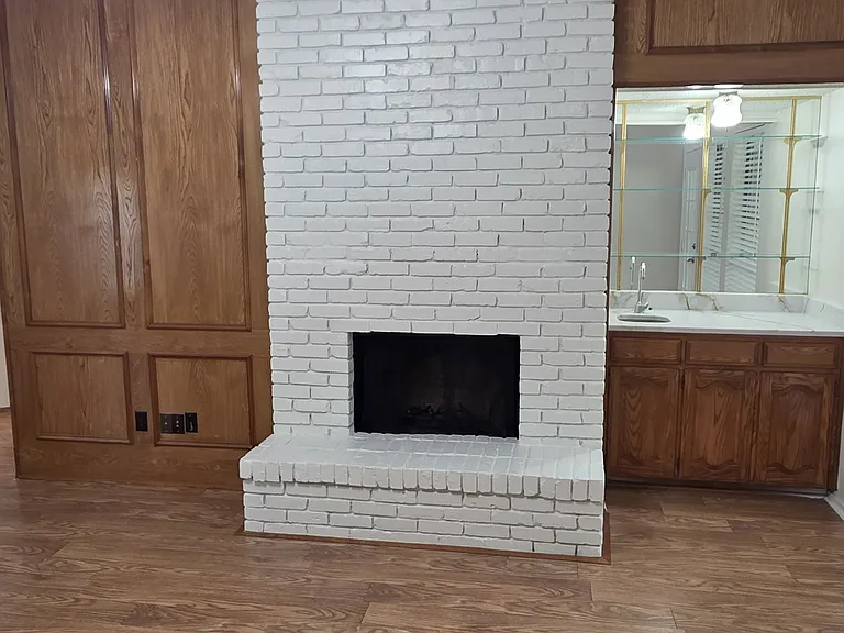 wood burning fireplace with a wet bar, new quartz counters and glass shelves