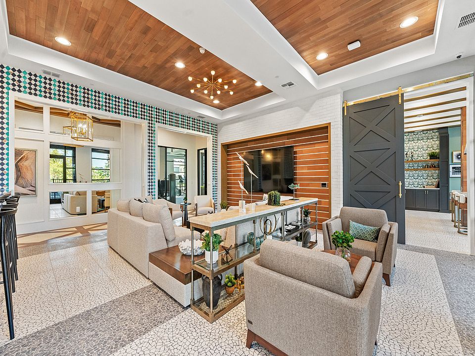 Luxurious living area with elegant decor, featuring plush seating, a stylish chandelier, and modern open shelving for a sophisticated ambiance.