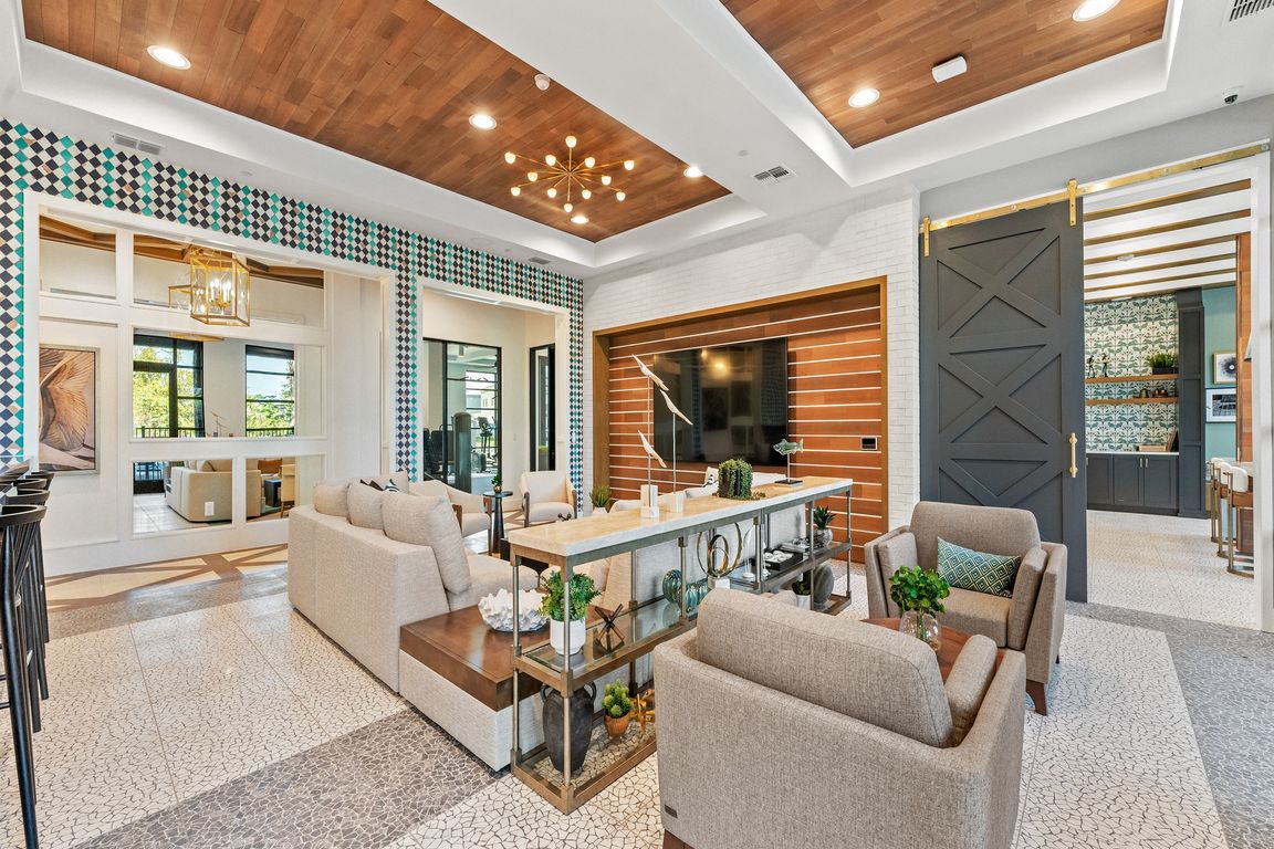 Luxurious living area with elegant decor, featuring plush seating, a stylish chandelier, and modern open shelving for a sophisticated ambiance.