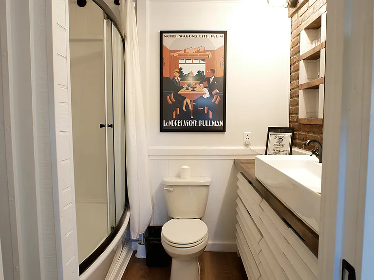 Custom main bath suite. Features: Sliding mirror for hidden storage, built in recessed shelving, dimmable lighting, double sink basin, linen closet, and oversized tub/shower combo with custom showerheads.
