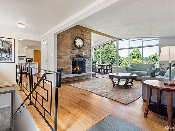 The original hardwoods, wood burning fireplace and wall of windows welcome you into this warm and inviting home.
