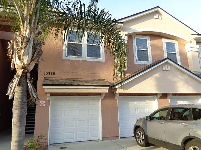 The townhome is located upstairs with the 4 windows overlooking a landscaped area across the street. The 2 windows on the left open to living room and the 2 windows on the right open to the master bedroom. The garage door on left has direct entrance to th