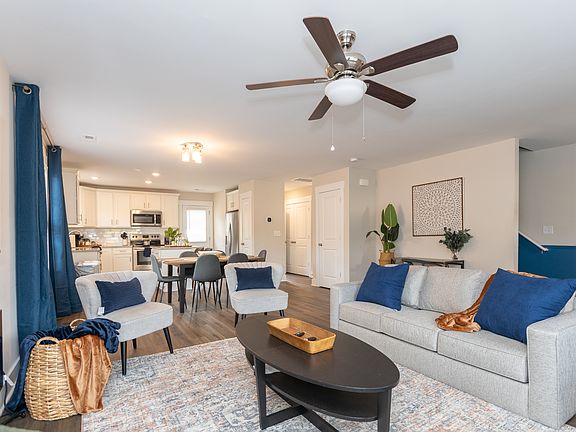 View of the living room to the kitchen open floor plan. Also, 65-inch TV, electric fireplace and workstation.