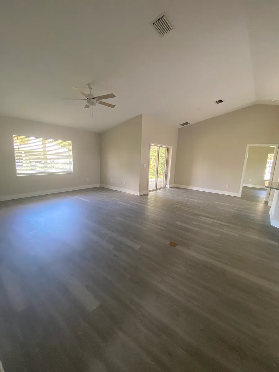Living room with dining area in background, kitchen to the right. For more furniture placement options there is an electrical outlet in the floor. - 765 Brookedge Ter
