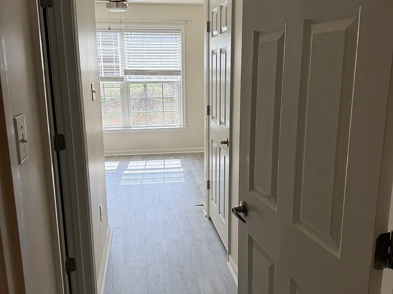 Entrance to primary bedroom, closet on right side, bathroom on left side.