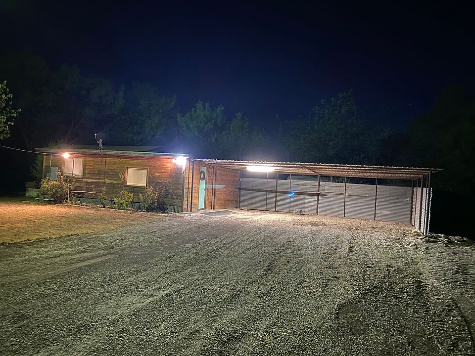 View of outside of the apartment at night.
Small shelf included under covered parking for outside storage as well.