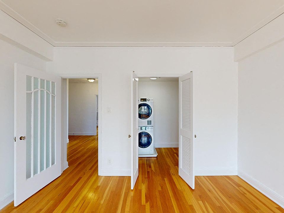 Living area with a wood-like flooring and a closet with an in-unit washer and dryer
