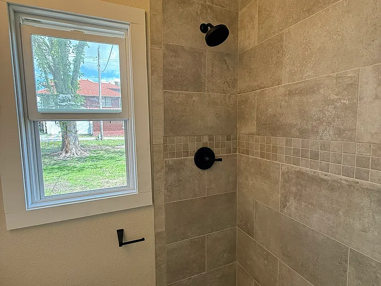 Downstairs updated bathroom with walk-in tile shower.